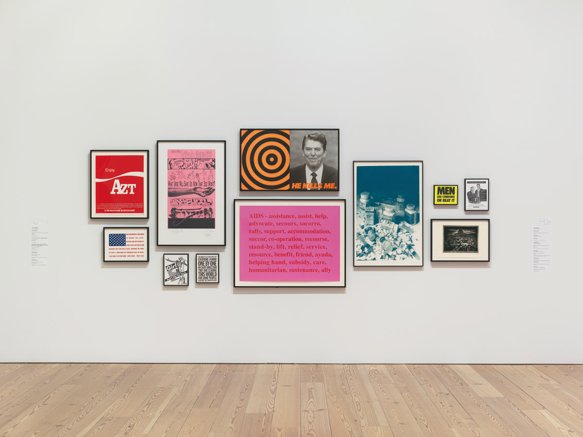 fig. 3: Installation view of An Incomplete History of Protest: Selections from the 	Whitney’s Collection, 1940-2017 (Whitney Museum of American Art, New York, August 18, 2017–). From left to right, top to bottom: Vincent Gagliostro and Avram Finkelstein, Enjoy AZT, 1989; Joseph Wolin, Tom Starace, and Richard Deagle, American Flag, 1989; John Ahearn, Andrew Castrucci, John “Crash” Matos, Chris “Daze” Ellis, Jane Dickson, Jenny Holzer,  Gary Simmons, and Martin Wong, The Usual Suspects, 1996; Barbara Kruger, (Girl don’t die for love), 1992; John Giorno, The world is getting empty…, 1993; Donald Moffett, He Kills Me, 1987; Kay Rosen, AIDS, 1994; Frank Moore, trial proof and study for the poster FACE IT—LICK IT, 1992; Gran Fury,  (Men use condoms or beat it), 1988; Glenn Ligon, (Who will keep their dreams alive if we don’t wake up to reality?), 1992; Sue Coe, Aids and the Federal Government, 1990. Photograph by Ron Amstutz. Digital image © Whitney Museum of American Art, New York.